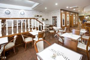 a restaurant with tables and chairs and a staircase at Oca Ipanema Hotel in Vigo