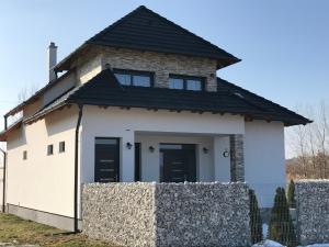 a white house with a black roof at Győri vendégház in Demjén