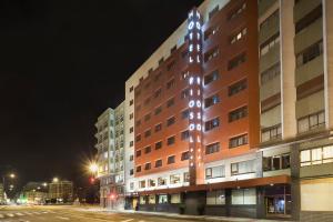 un edificio con luci sul lato di esso di notte di Crisol Riosol a León