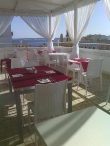 ein Restaurant mit weißen Tischen und weißen Stühlen mit Aussicht in der Unterkunft Hotel Città Bella in Gallipoli