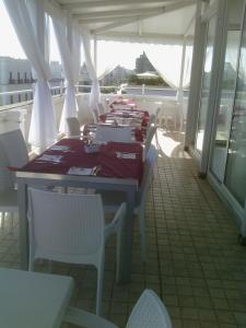 eine Gruppe von Tischen und Stühlen auf einem Balkon in der Unterkunft Hotel Città Bella in Gallipoli