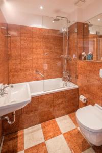 a bathroom with a tub and a toilet and a sink at Hotel Deutscher Kaiser in Nürnberg