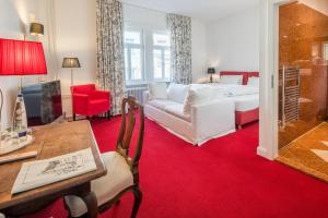 a living room with a white couch and a table at Hotel Deutscher Kaiser in Nürnberg