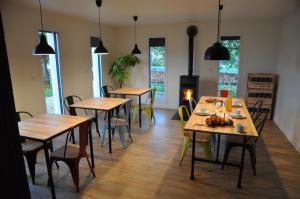 - une salle à manger avec des tables, des chaises et des fenêtres dans l'établissement L'Atelier, à Sainte-Marie-du-Lac-Nuisement 