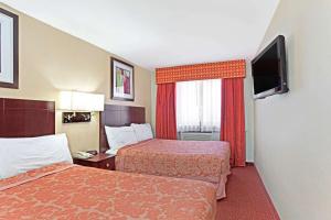 A bed or beds in a room at Super 8 by Wyndham Long Island City LGA Hotel