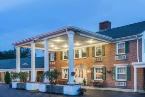 een groot bakstenen gebouw met witte zuilen bij Colonial Inn Seekonk in Seekonk