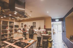 un groupe de personnes debout dans une cuisine dans l'établissement The Black Sheep Hostel, à Killarney