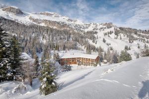 un lodge de esquí en una montaña cubierta de nieve en Hotel Garni Elisir, en Arabba