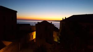 einen Blick auf den Sonnenuntergang von den Gebäuden einer Stadt in der Unterkunft Casa ANNA in Calvi