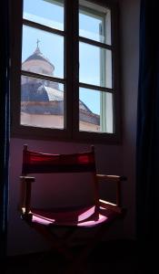 einer Bank unter einem Fenster mit Blick auf ein Gebäude in der Unterkunft Casa ANNA in Calvi