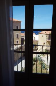 ein offenes Fenster mit Blick auf ein Gebäude in der Unterkunft Casa ANNA in Calvi