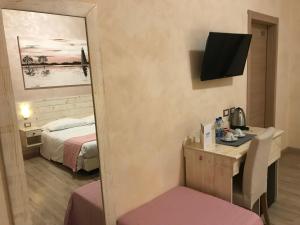 um quarto de hotel com uma cama e um espelho em Fiumicino Airport B&B Deluxe em Fiumicino