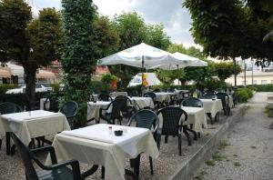 een groep tafels en stoelen met witte tafels en parasols bij Hotel Riviera in Griante Cadenabbia