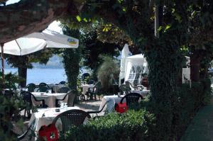 een openluchtrestaurant met tafels en stoelen en het water bij Hotel Riviera in Griante Cadenabbia