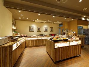 eine große Küche mit einem Buffet mit Speisen in der Unterkunft Hotel Sunroute Sopra Kobe in Kōbe