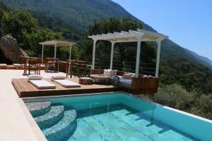 - une piscine avec une table et un canapé à côté d'une montagne dans l'établissement Ölüdeniz Loft - Adults Only, à Ölüdeniz