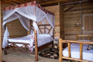 een slaapkamer met 2 bedden in een blokhut bij Living Waters Resort in Jinja