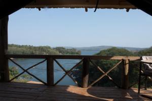 een uitzicht vanaf het dek van een hut met uitzicht op het water bij Living Waters Resort in Jinja