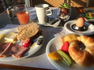 einen Tisch mit zwei Teller Essen mit Brot und Obst in der Unterkunft Hôtel du Port in Lausanne