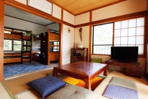 a living room with a table and a tv at Midorian in Nikko