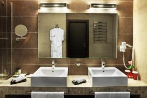 a bathroom with two sinks and a large mirror at Mirotel Resort and Spa in Truskavets