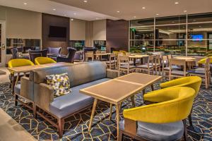 un ristorante con tavoli, sedie e un divano di Hyatt House Raleigh/Rdu/Brier Creek a Raleigh