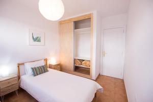 a bedroom with a white bed and a cabinet at Surfers Retreat in Corralejo