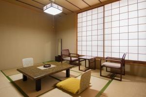 una sala de espera con mesas y sillas y una gran ventana en Hotel Seikoen, en Nikko