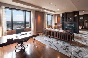 a living room with a desk and a tv at HOTEL MYSTAYS PREMIER Narita in Narita