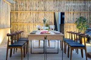 a wooden table with chairs and wine glasses on it at Lijiang Gemmer Hotel in Lijiang