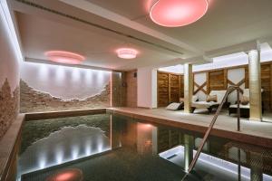 a house with a pool in the middle of a room at Hotel Garni Savoy in Castelrotto