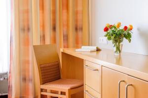 un bureau avec un vase de fleurs et un vase de fleurs dans l'établissement Hotel Kurhaus Bad Bocklet, à Bad Bocklet