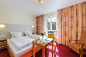 une chambre d'hôtel avec un lit et une table dans l'établissement Hotel Kurhaus Bad Bocklet, à Bad Bocklet