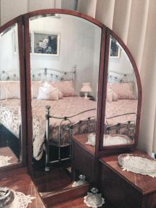 1 dormitorio con cama y espejo grande en Belvoir B&B Cottages, en Grafton