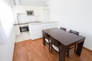 a kitchen with a table and chairs in a room at Domocenter Apartamentos Turísticos in Bormujos