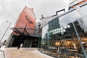 una tienda frente a un edificio con ventanas de cristal en Malmaison Manchester, en Mánchester