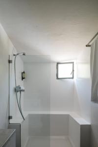 bagno bianco con doccia e finestra di Tres Marias a Vila Nova de Milfontes