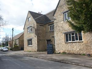 a brick building with a sign in front of it at Bear and Ragged Staff in Oxford