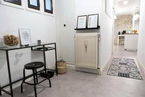 une chambre avec un radiateur, une table et un tabouret dans l'établissement Gite Bons Amis, à Dijon