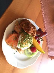 einen Teller mit Eiern und Obst auf dem Tisch in der Unterkunft Pension Cafe Suzette in Gotha