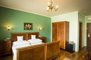 a bedroom with a large bed with green walls at Hotel Bojnický vínny dom in Bojnice