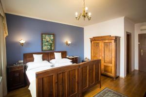 a bedroom with a large bed and a chandelier at Hotel Bojnický vínny dom in Bojnice