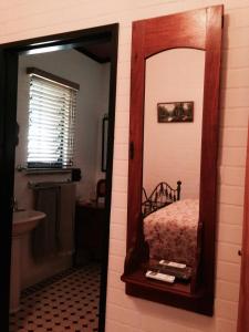 espejo en el baño con cama y lavabo en Belvoir B&B Cottages, en Grafton