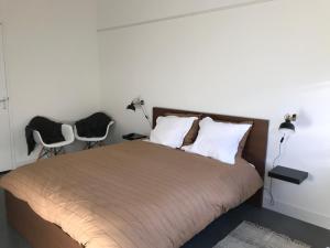 1 Schlafzimmer mit einem großen Bett und 2 Stühlen in der Unterkunft Bij Zelle in Garderen