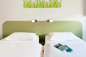 2 letti posti uno accanto all'altro in una camera da letto di ibis budget Saint Malo Centre a Saint Malo