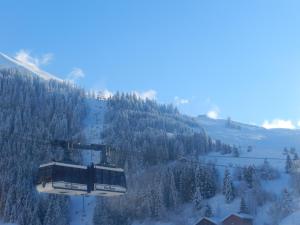 um teleférico que sobe uma montanha coberta de neve em Chalet-Hôtel du Borderan em La Clusaz