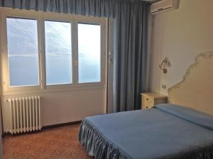 una camera con un letto e una grande finestra di Hotel Villa Margherita a Limone sul Garda