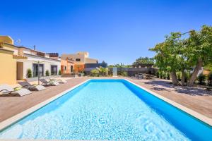 - une piscine avec des chaises et une maison dans l'établissement Villas Marim, à Olhão