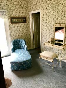 sala de estar con silla azul y espejo en Rabbit Creek Bed & Breakfast, en Versailles