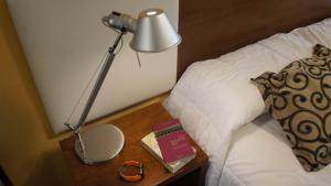 a lamp on a table next to a bed at Palm Beach Plaza Hotel in Montevideo